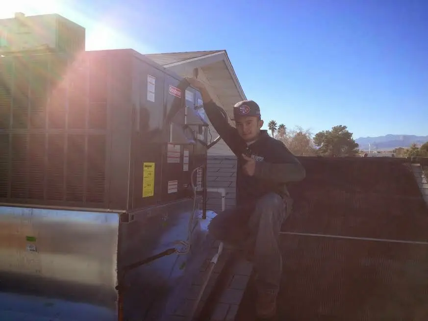 HVAC technician performing Air Duct Cleaning on a rooftop unit in Luzerne